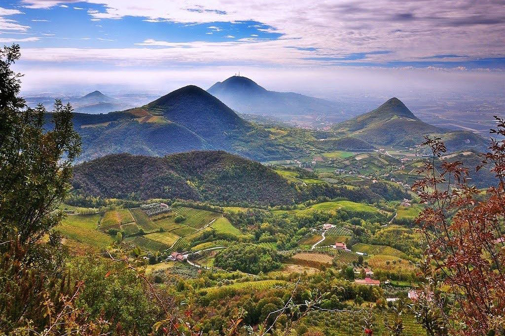 Panorama sui Colli Euganei con colline verdi e cielo nuvoloso, perfetto per avventure all'aria aperta.